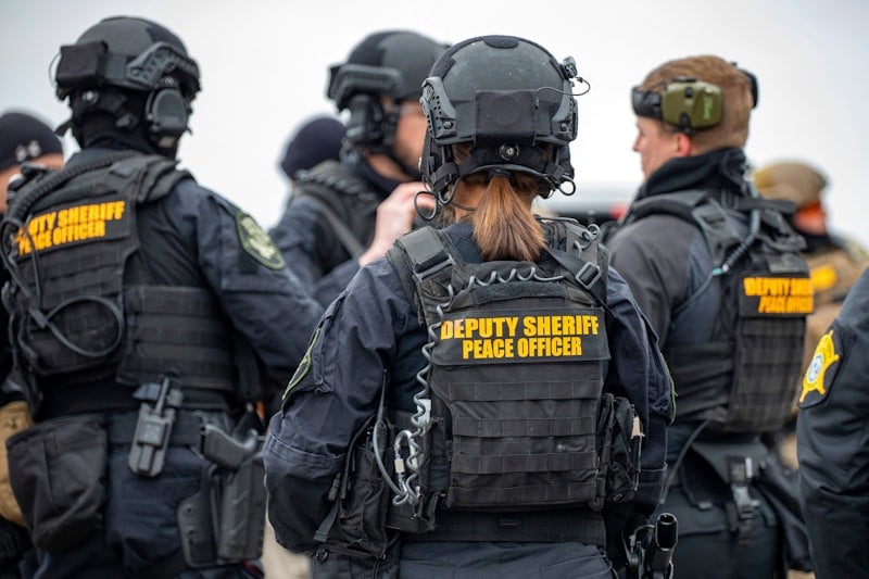 Police personnel with their backs to the camera
